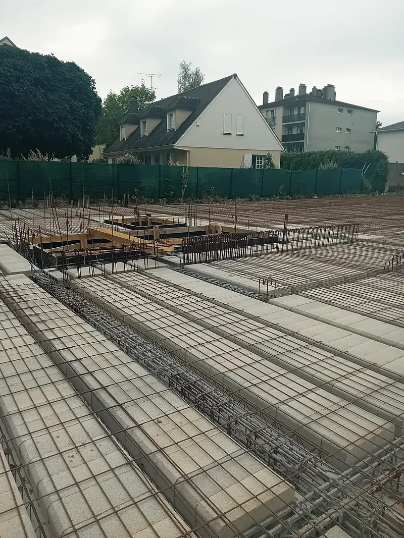 Plancher en poutrelles et entrevous béton recouvert de treillis soudé et d’armatures, avant coulage.