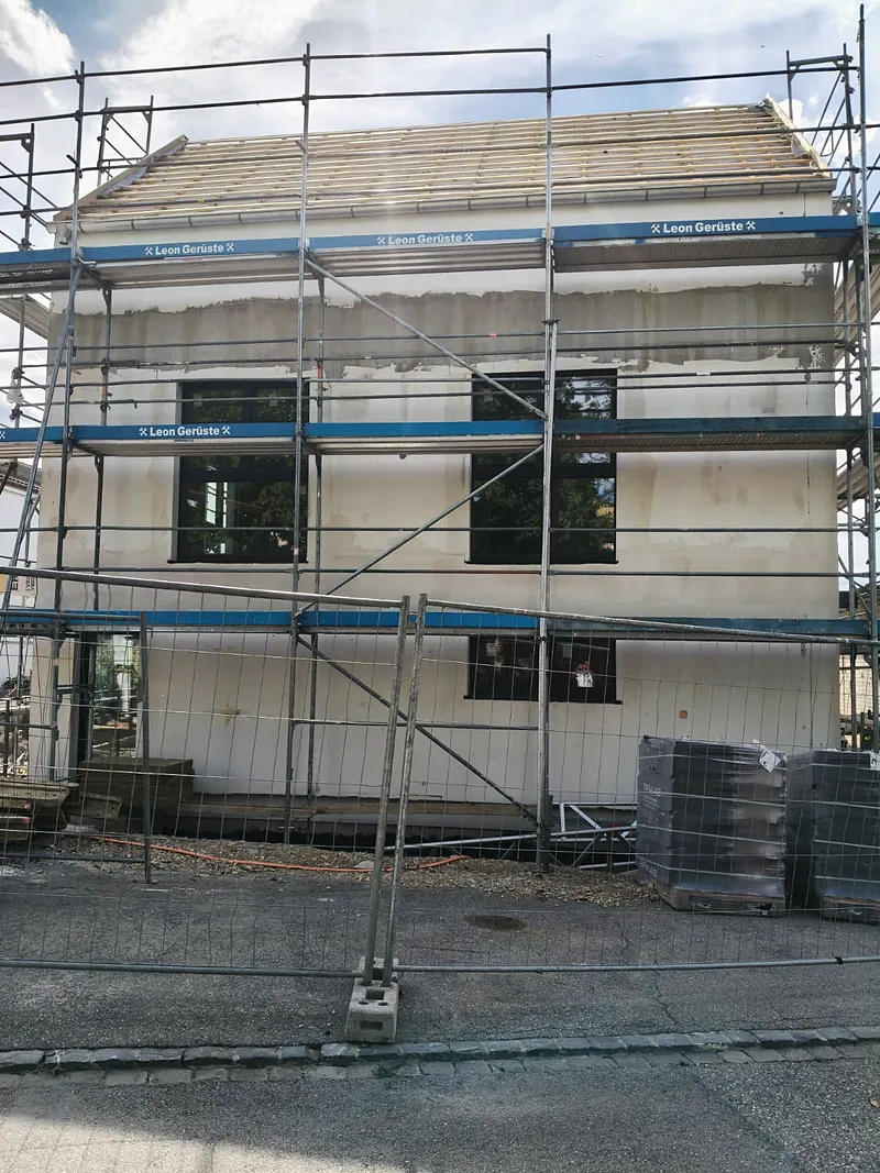 Maison en construction sous échafaudage.