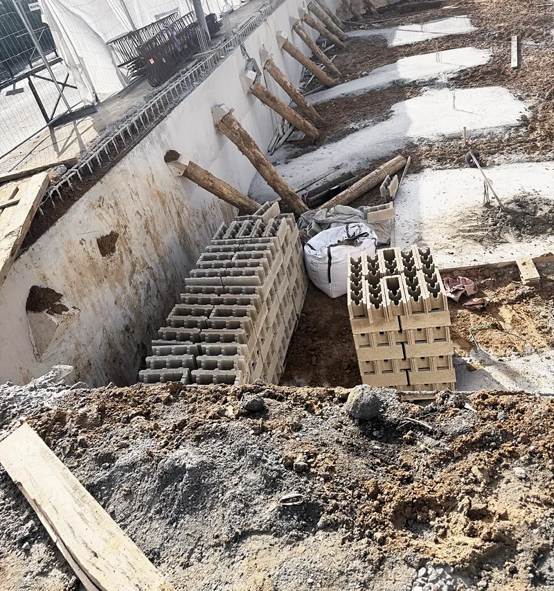 Parois tenues par des butons, blocs béton approvisionnés.