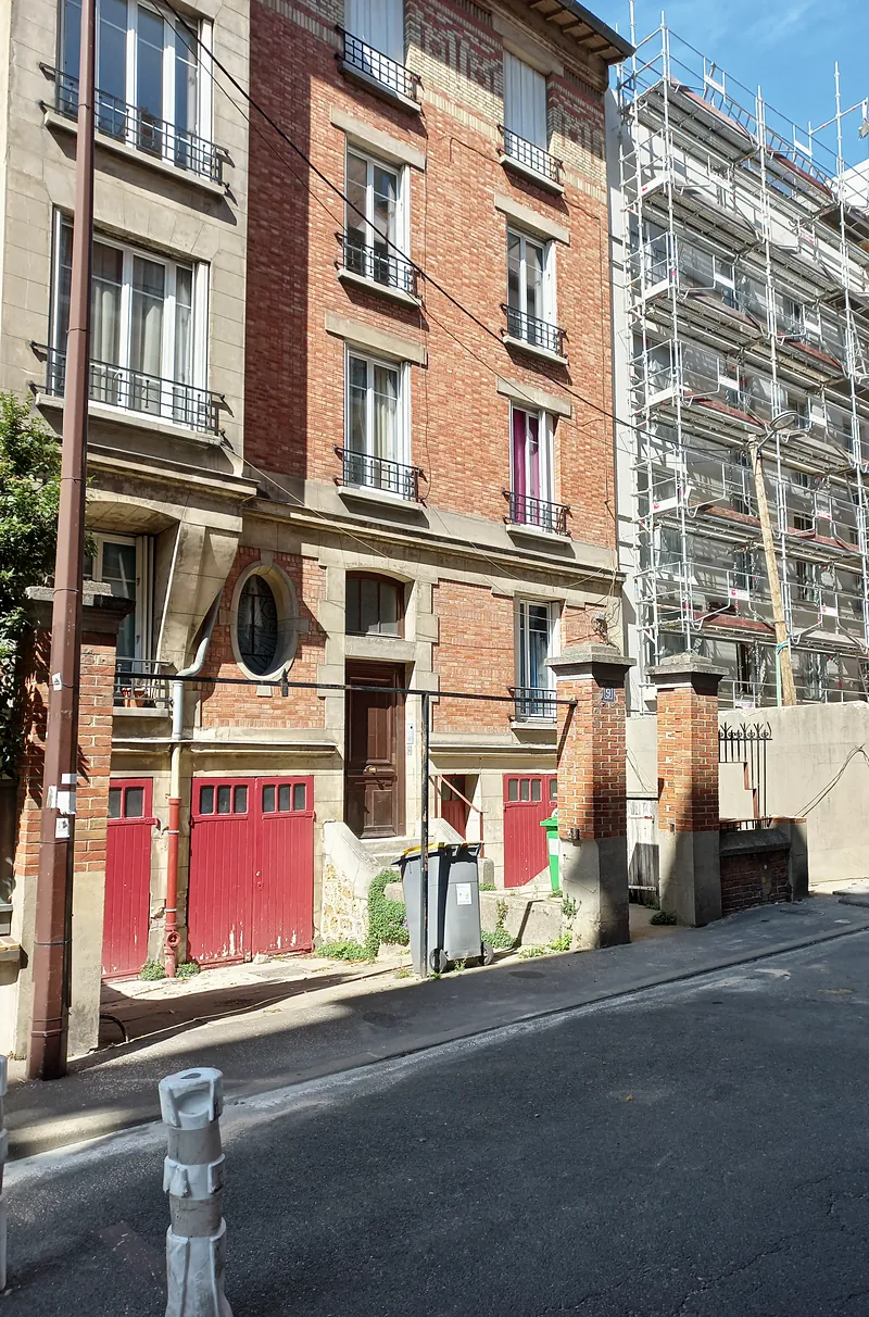 La rue, façade en cours de ravalement sous échafaudage.
