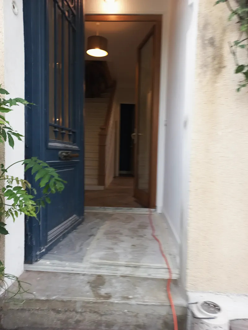 L’entrée et l’escalier, derrière la porte bleue.