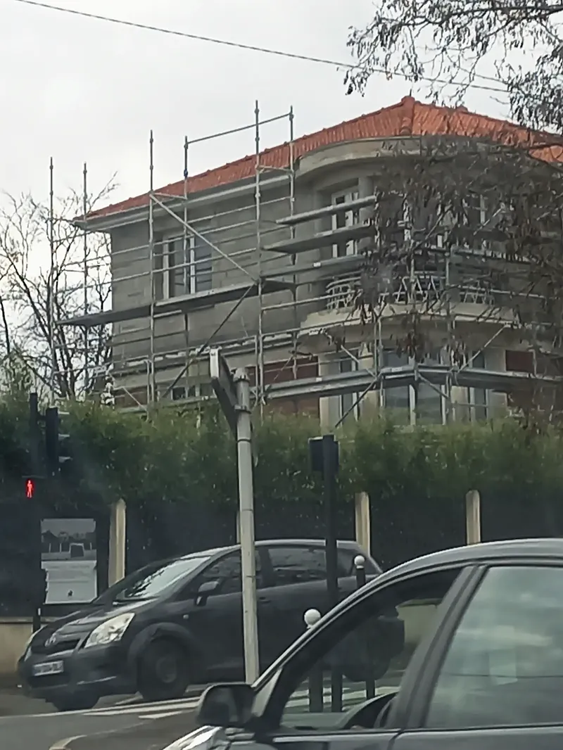 La villa sous échafaudage pendant les travaux de surélévation, toiture en tuiles rouges.